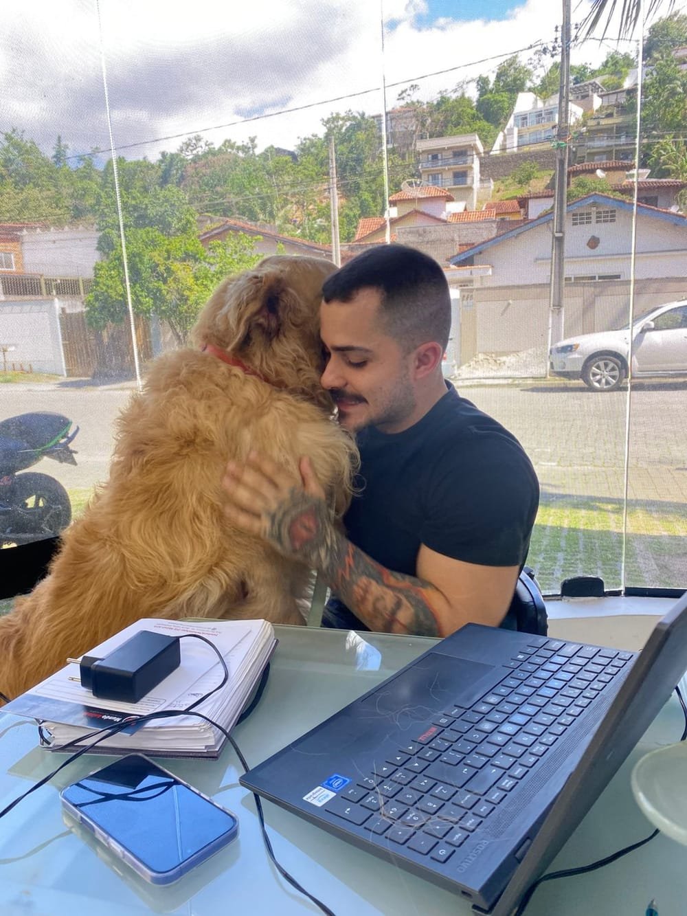 Veterinário abraçando um golden retriever na recepção da clínica